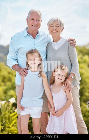 Nothings more important than family. an affectionate mature couple and their granddaughters in a park. Stock Photo