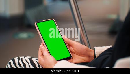 Woman hands close up watching on the phone on green screen chroma key on the train. Stock Photo