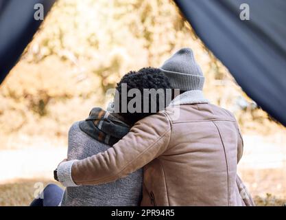 Lets stay here and never go back. a young couple enjoying the scenery while camping. Stock Photo