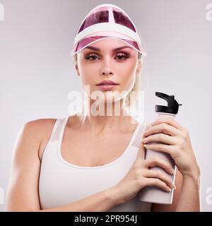 A real girl isnt perfect, and a perfect girl isnt real. Studio shot of a sporty young woman posing against a grey background. Stock Photo