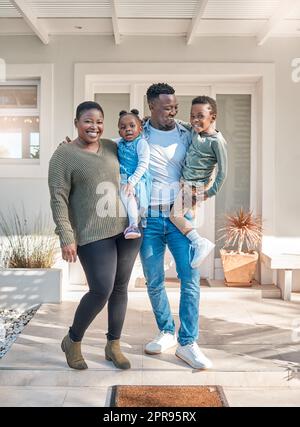 Home is our happiest, cosiest nest. Portrait of a happy family standing together outside their home. Stock Photo