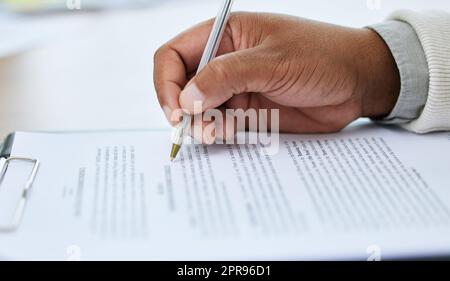 Going over every detail before signing the agreement. Closeup shot of an unrecognisable man going through paperwork. Stock Photo