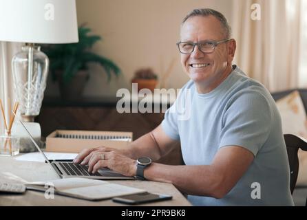 I love being able to work from home. a mature man typing on his laptop. Stock Photo