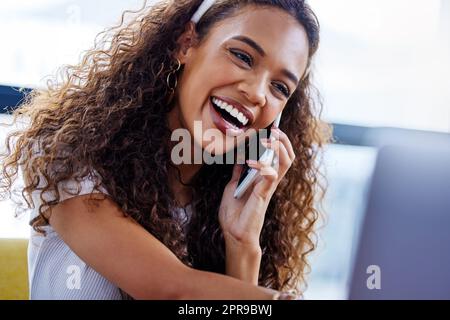 Thats so great to hear. a young businesswoman talking on a cellphone in an office. Stock Photo