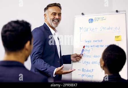 Lets discuss this topic. a mature businessman giving a presentation in a boardroom at work. Stock Photo