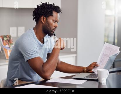 Better be better days on the way. a man going through some paperwork and looking worried at home. Stock Photo