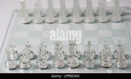 Transparent chess figures, on starting position, on reflective chess board. Chess board game Stock Photo