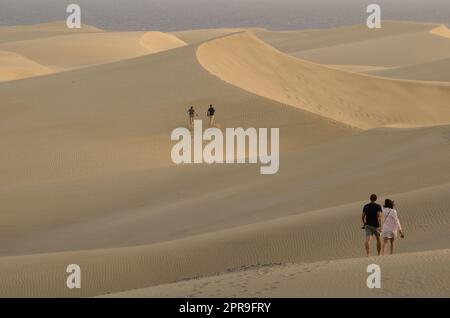 People walking in sand dunes. Stock Photo