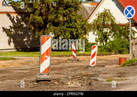 Red and white striped traffic control devices for avoiding sections of the road being repaired Stock Photo