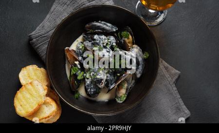 Blue mussels  stewed in cream wine sauce with garlic and herbs. Italian or French traditional food Stock Photo