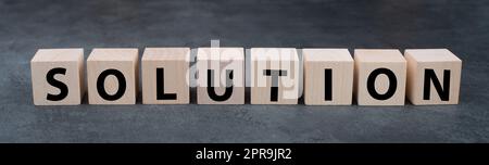 The word solution is standing on wooden cubes, solving a problem, having a business target Stock Photo