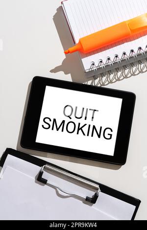 Text caption presenting Quit Smoking. Word for Discontinuing or stopping the use of tobacco addiction Tablet With Important Message Between Clipboard, Notebook And Marker. Stock Photo