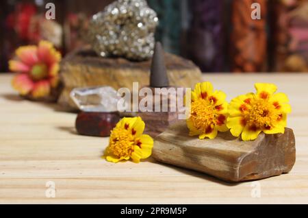 Yellow Flowers on Petrified Wood With Rock Crystals and Incense Cone Stock Photo