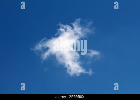 Simple mist like small fluffy pure cotton white single cloud on perfectly clear blue sky background Stock Photo