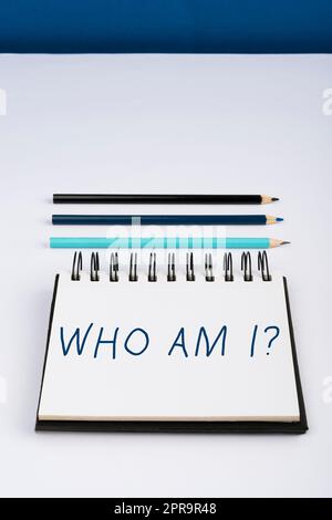 Hand writing sign Who Am I. Business approach Introduce Identify yourself personality likes dislikes profile Important Informations Written On Notebook Next To Pencils. Stock Photo