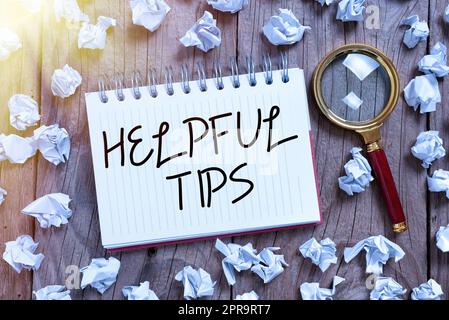 Conceptual display Helpful Tips. Internet Concept Useful secret Information Advice given to accomplish something Note With Important Data Written In With Paper Wraps And Magnifier Around. Stock Photo