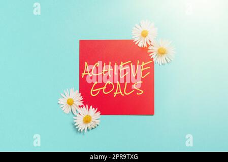 Inspiration showing sign Achieve Goals. Business idea Results oriented Reach Target Effective Planning Succeed Sticky Note With Important Messages With Flowers On Both Sides. Stock Photo