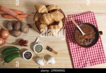 Beef Stew and Fresh Bread in Rustic Kitchen With Red and White Checkered Cloth Stock Photo