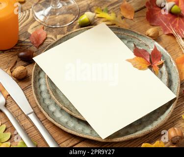 Autumn rustic table setting with blank card between leaves and berries close up mockup Stock Photo