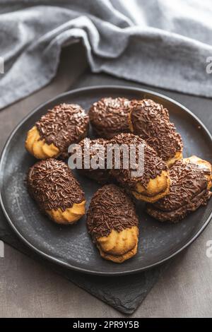 Petit fours with chocolate sprinkles. Mini chocolate dessert on plate. Stock Photo