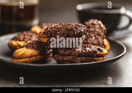 Petit fours with chocolate sprinkles. Mini chocolate dessert on plate. Stock Photo