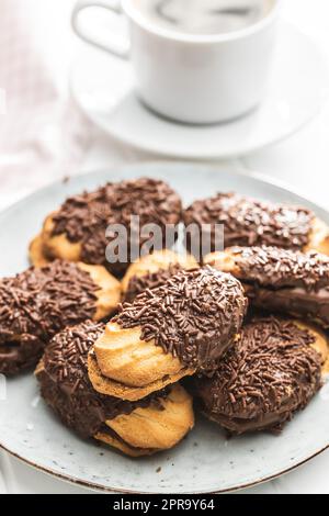 Petit fours with chocolate sprinkles. Mini chocolate dessert on plate. Stock Photo