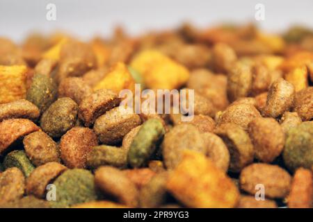 Dry food for cats, dogs lies in a pile on a light background. Close-up. Blurred background and background Stock Photo