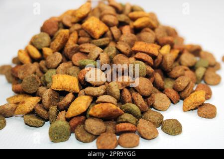 Dry food for cats, dogs lies in a pile on a light background. Close-up. Blurred background and background Stock Photo