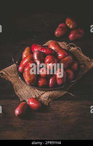 Organic raw red potatoes on wooden background Stock Photo