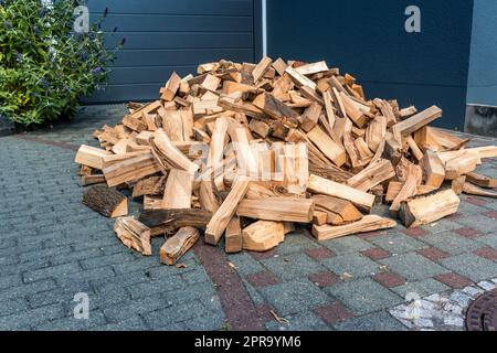 Stock of firewood for heating house. Stacked dried logs in front of the house Stock Photo