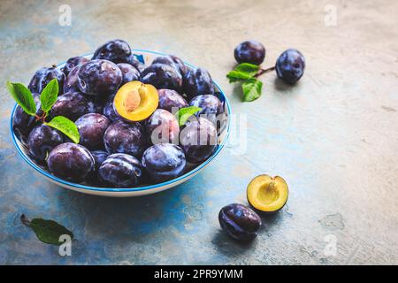 Freshly picked prune plums (Zwetschgen) fruits in bowl Stock Photo