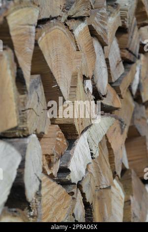 Close-up stack of chopped wood intended to be burned, typically for heat. Typical wooden texture with the age rings are visible on the cut surface. Stock Photo