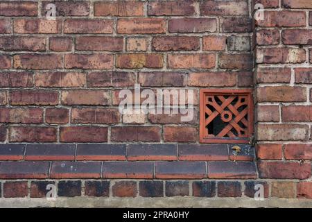 Red brick wall with ventilation brick Stock Photo
