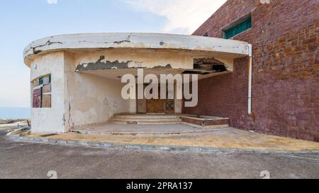 Entrance of abandoned old house by the sea with grunge weathered wooden double leaves door and brown stone bricks Stock Photo