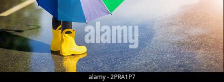 Child standing in the puddle in yellow rubber boots Stock Photo - Alamy