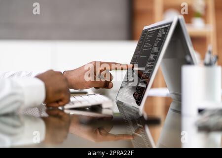 African American Coder Using Computer At Desk Stock Photo