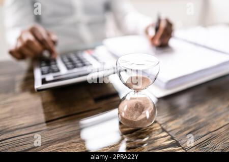 Late Invoice And Billing Deadline With Hourglass Stock Photo