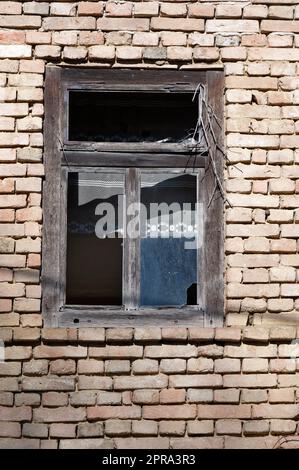 Detail of old broken window on brick wall Stock Photo