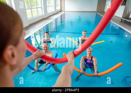 People in aqua fitness class during a physical therapy session Stock Photo