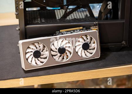 Gigabyte GeForce RTX 3060 Ti GPU, graphics card laying next to a new PC case, upgrading, installing, buying a new graphic processing unit, 3 fans high Stock Photo