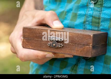 Man holding a simple small closed classy stylish wooden box, container. Gift, present, important items storage, carrying case abstract concept, object Stock Photo