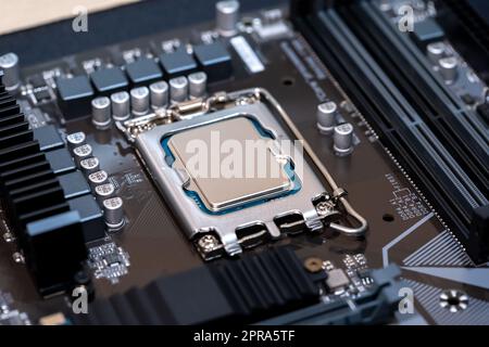 Modern CPU processor installed on a brand new motherboard, object detail, extreme closeup, nobody. Simple generic powerful high end gaming CPU up clos Stock Photo
