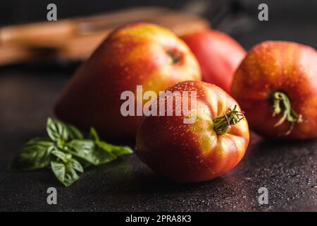Bull heart tomatoes on black table. Stock Photo