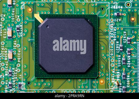 Closeup of micro processor chip on motherboard in computer. Green printed circuit board. PCB.  Computer and networking communication technology concept. Green technology background. Stock Photo