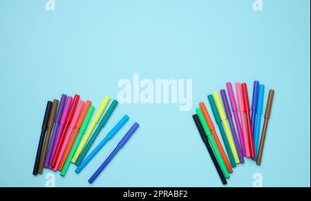 Stack of multicolored felt-tip pens on a blue background Stock Photo