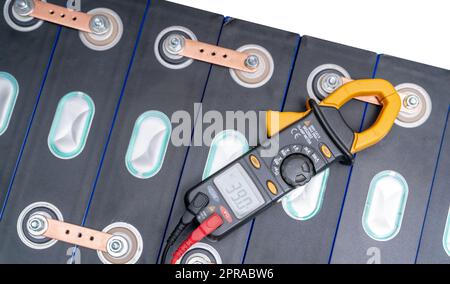 Electric vehicle lithium NMC battery. Electric car battery. Lithium-ion cell pack. Lithium NMC rechargeable battery. EV car energy storage. Multimeter measuring volts of electric vehicle battery. Stock Photo