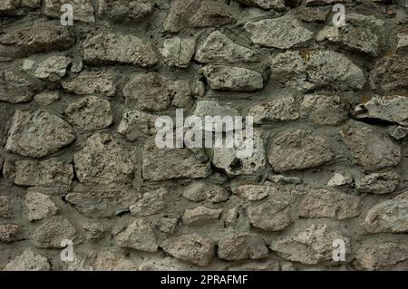 abstract grunge background: rough wall of granite stones and concrete Stock Photo