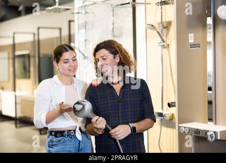 Nice couple looking to buy shower fixtures in hardware store Stock Photo