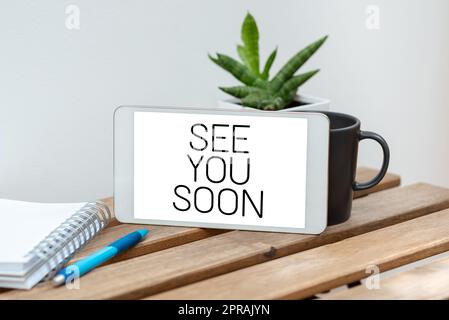 Handwriting text See You Soon. Concept meaning Farewell we will meet again in a short period of time Speech Bubble With Important Announcement Placed On Table With Coffee. Stock Photo