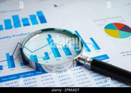 Magnifying glass on charts graphs paper. Financial development, Banking Account, Statistics, Investment Analytic research data economy. Stock Photo